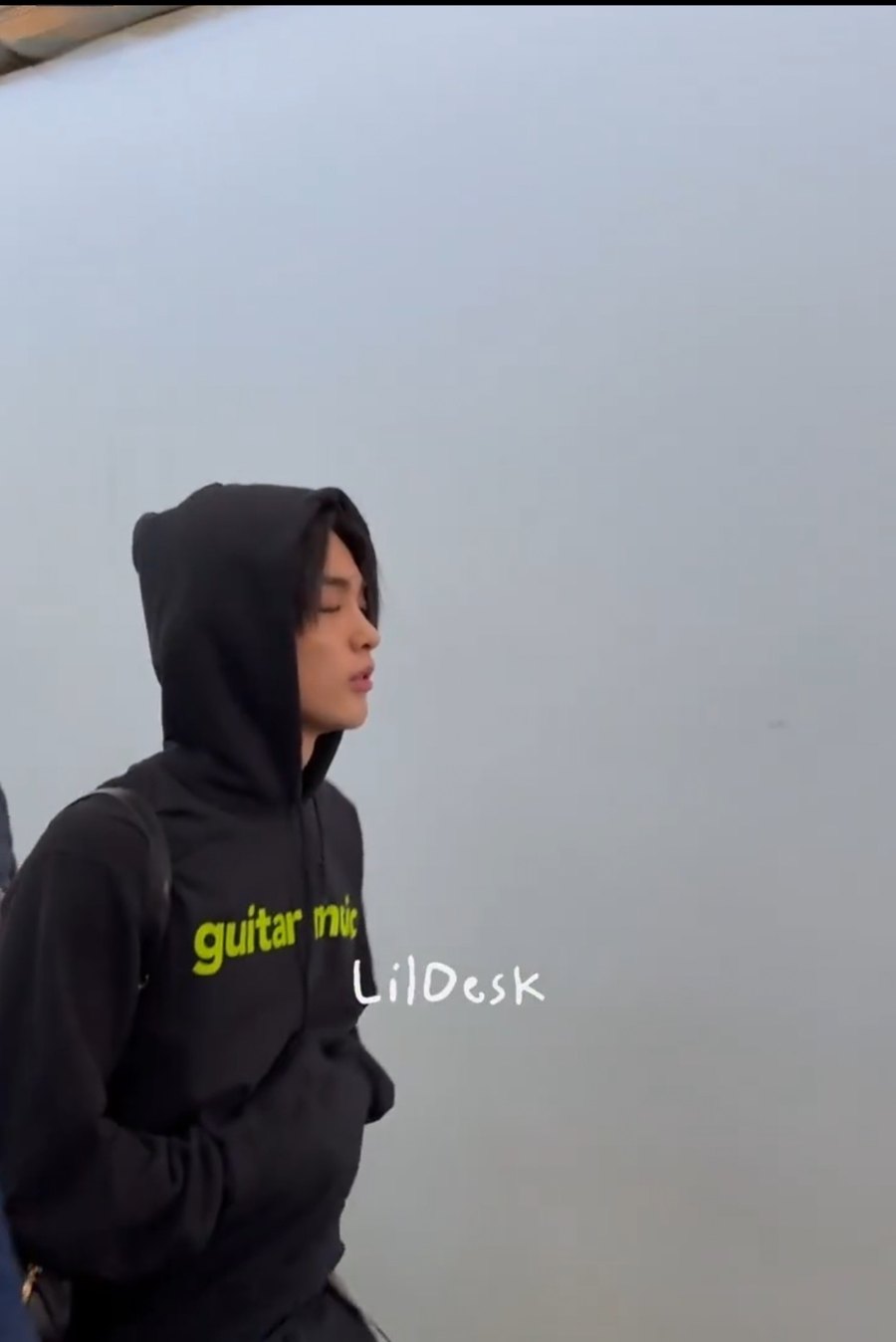 Keonho of CORTIS in Paris wearing the black Dominic Fike guitar music hoodie on his way to the Chanel fashion show