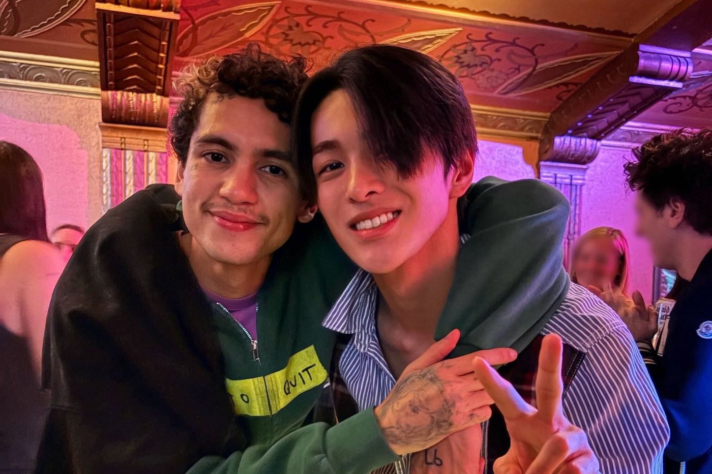Keonho of CORTIS with Dominic Fike at his concert, both smiling, Keonho making a peace sign