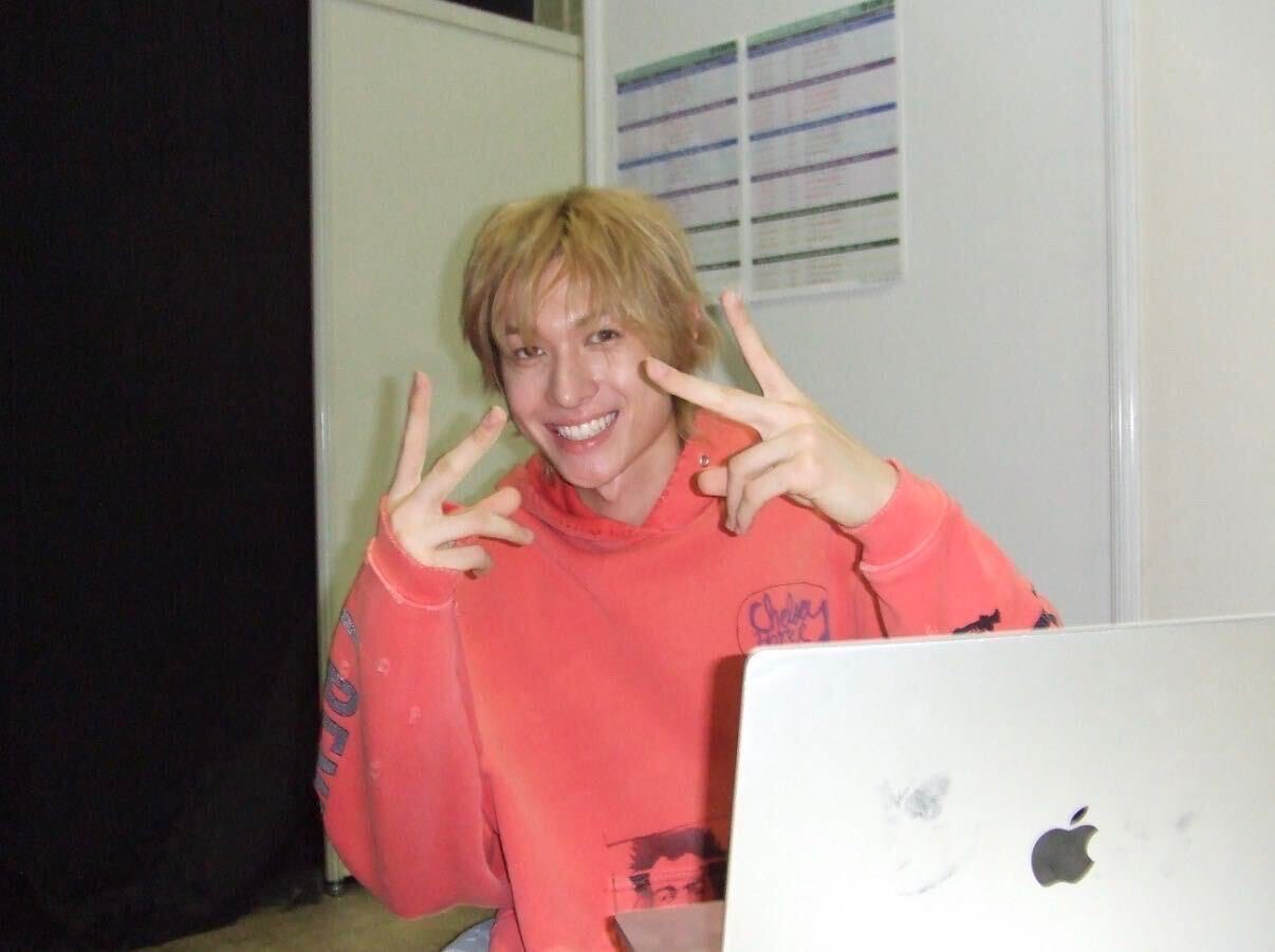 Martin of CORTIS smiling behind a laptop backstage, photographed on a compact camera