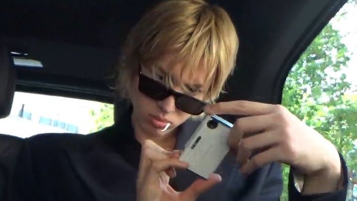 Martin of CORTIS in a car holding his compact digital camera