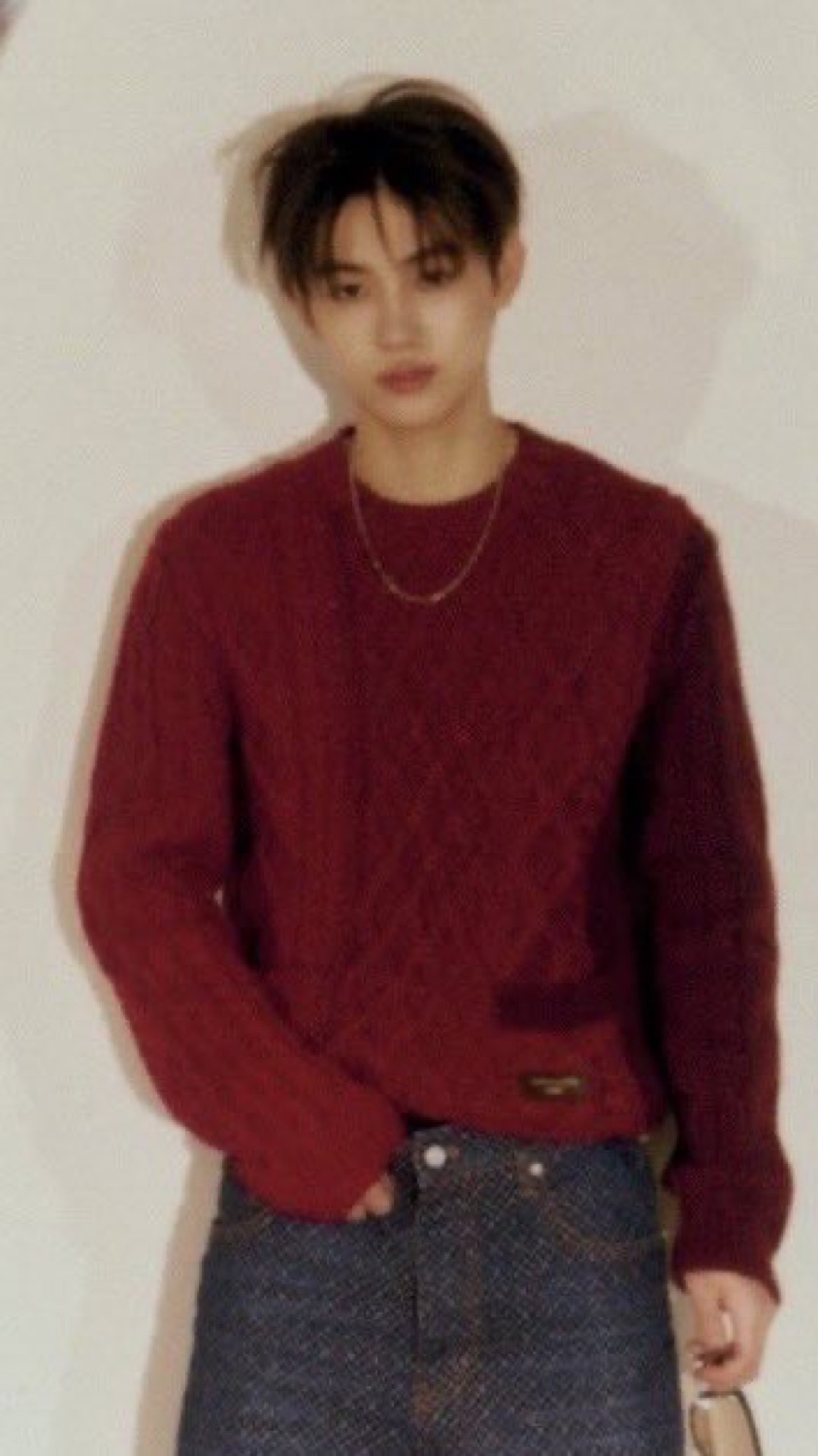 Portrait of Seonghyeon of CORTIS in a red Louis Vuitton cable knit with a gold chain