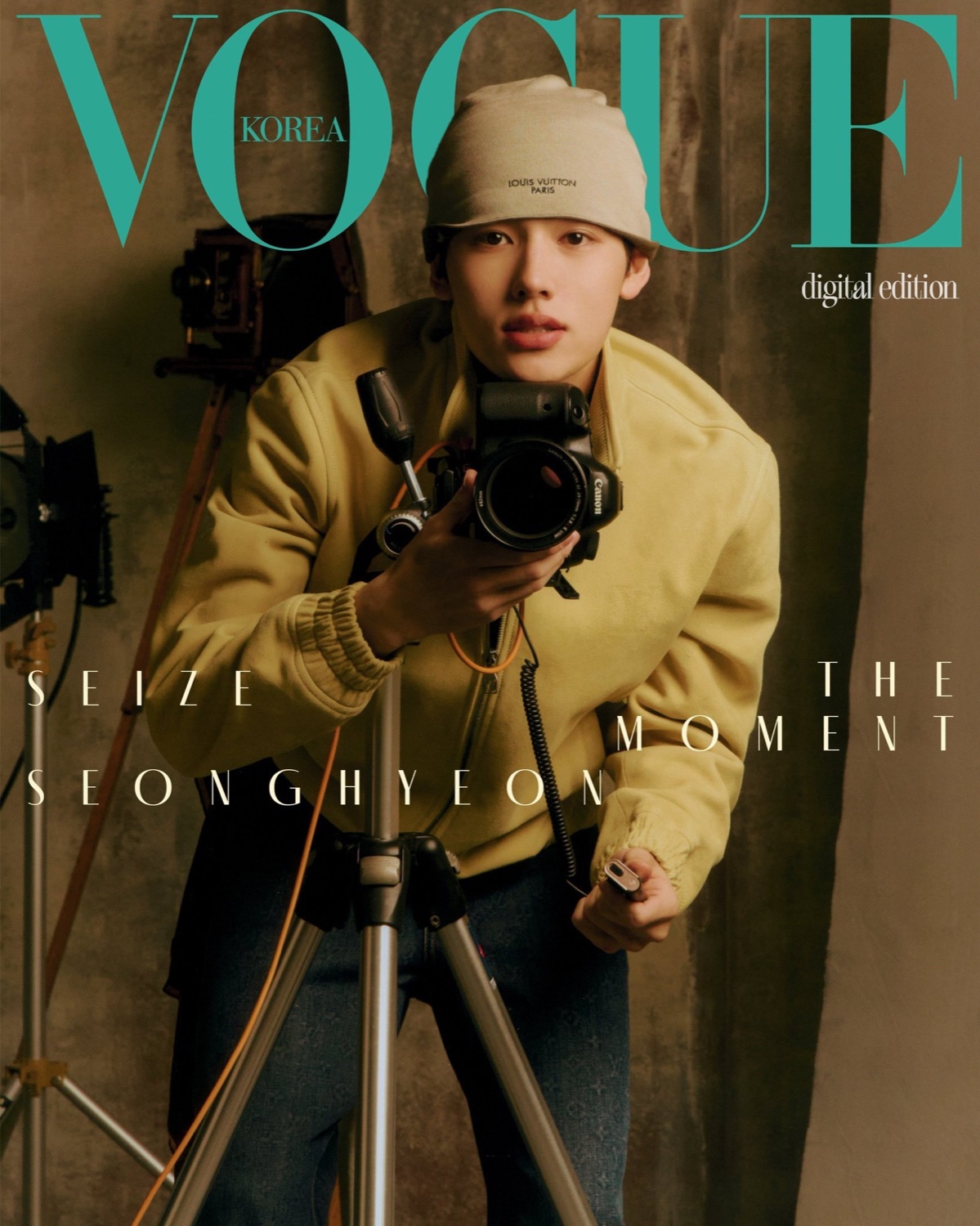 Seonghyeon of CORTIS on the cover of Vogue Korea in a yellow Louis Vuitton bomber jacket, holding a Canon camera on a tripod, under the line Seize the Moment