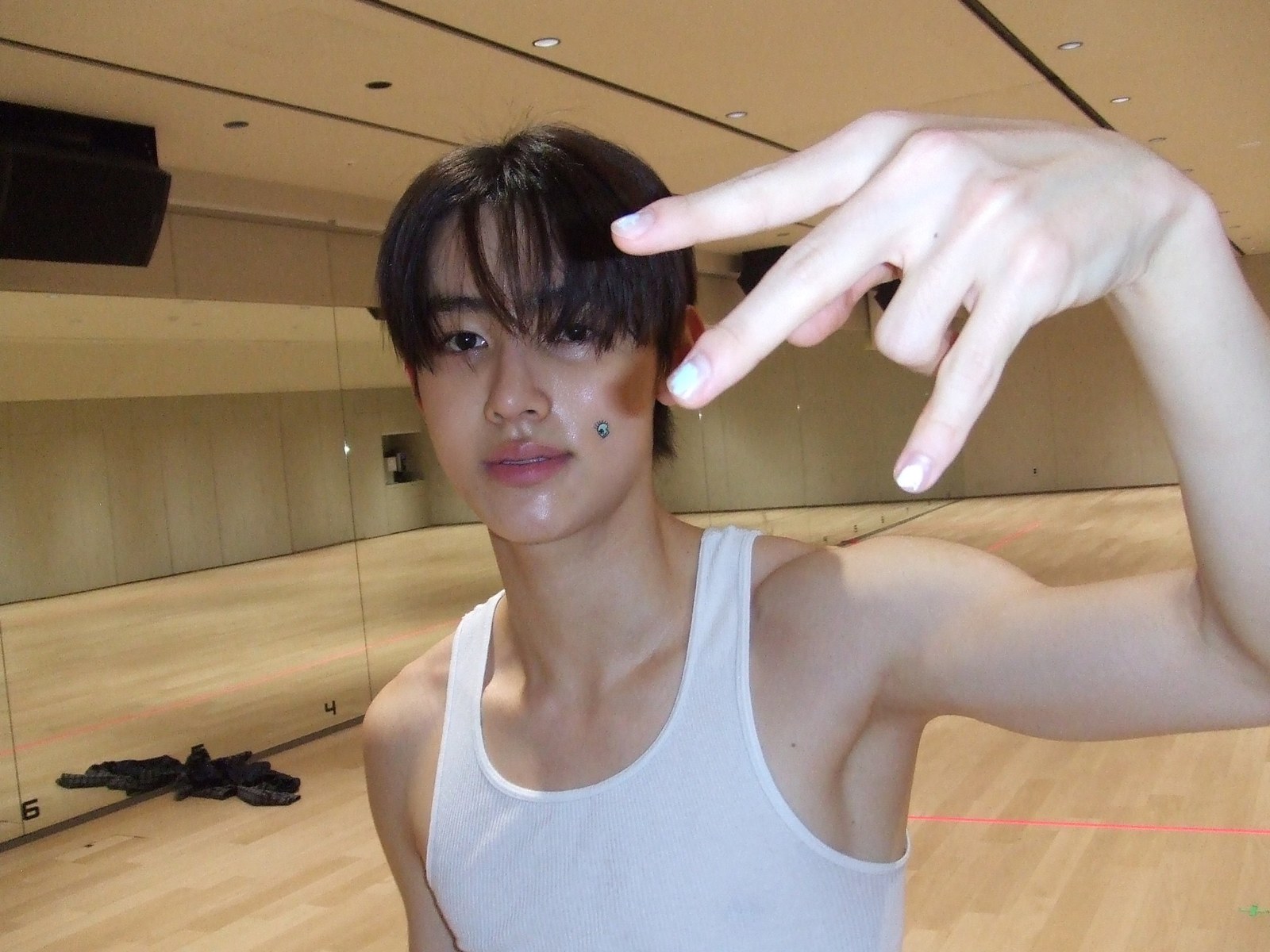 Seonghyeon of CORTIS in a practice room, throwing a peace sign at the mirror