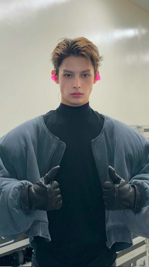 CORTIS James phone lock screen, backstage in an oversized grey bomber jacket