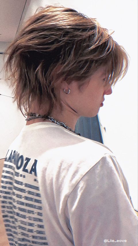 CORTIS Martin phone lock screen, seen from behind in a white Lollapalooza t-shirt