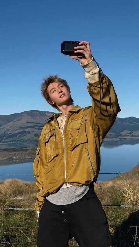 CORTIS Martin phone wallpaper, taking a photo on a camera in a gold jacket