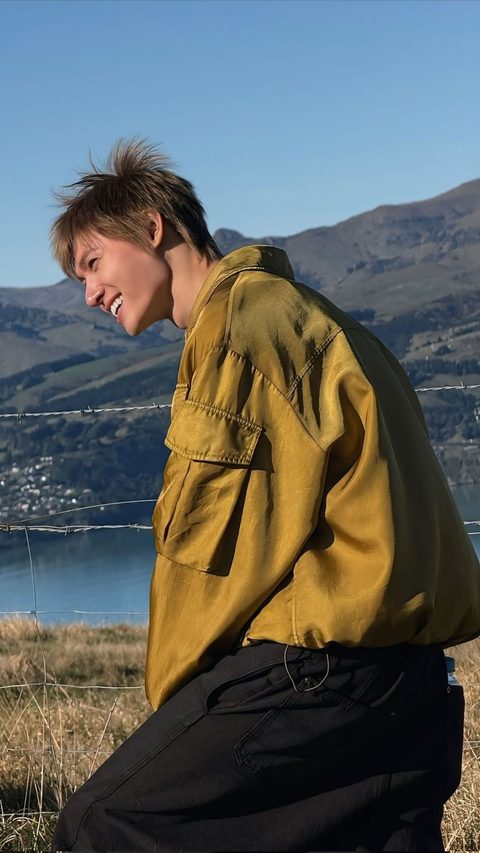 CORTIS Martin phone wallpaper, laughing in a gold jacket in front of the hills