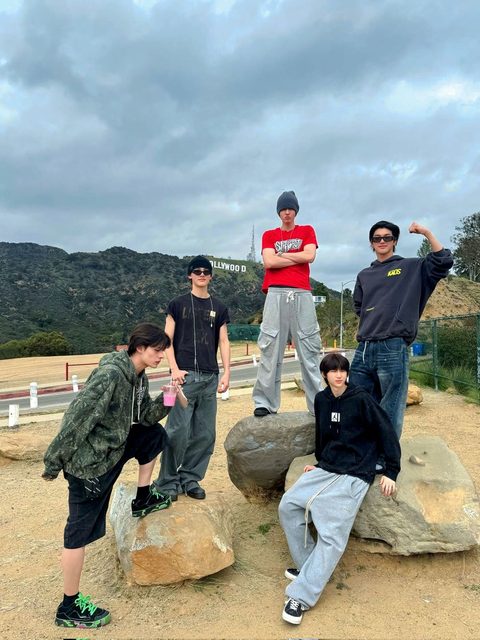 CORTIS phone wallpaper, all five members posing on rocks in front of the Hollywood sign
